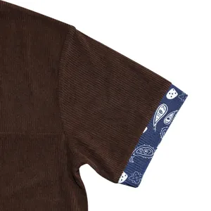 Men's corduroy short sleeve shirt detail view featuring contrast paisley pattern cuff.