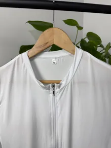 Close-up detail of white knitted men bodysuit with front zipper and M size collar tag.