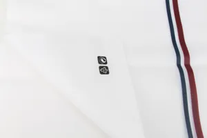 White frosted plastic packaging bag detail with classic stripe design and recycling symbols.