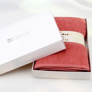 White gift box with folded red cotton bath towel set for home use and hotel supply.