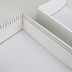 White thick cardboard gift box packaging detail showing inner structure and clean striped trim.