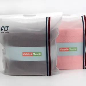 Ensemble de serviettes de bain en coton dans un emballage portable givré, produit textile.