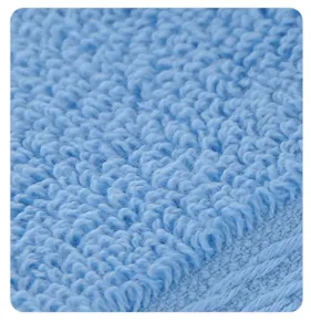 Close-up detail of soft blue cotton towel showing fine loops and woven border texture.