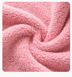Close-up view of soft pink cotton towel loop texture, showing premium fabric quality.