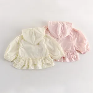 Détail veste légère à capuche en dentelle bébé fille, cardigan rose et jaune d'été.