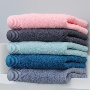 Ensemble de serviettes en coton unies, douces et absorbantes empilées pour un usage quotidien.