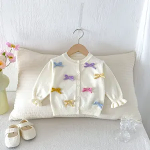 Cute baby girl knit cardigan with colorful bows, soft off-white sweater top detail