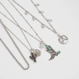 Detail of Western cowboy silver necklace set with cactus and turquoise boot charms.