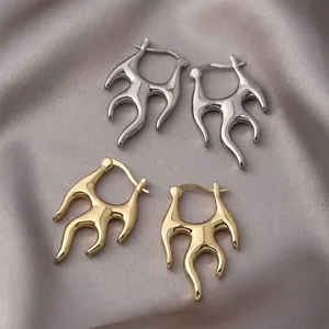 Nahaufnahme von flammenförmigen Creolen in poliertem Gold- und Silber-Finish für Damen