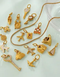 Detailed macro view of 18K gold plated vintage DIY charms in airplane and key shapes.
