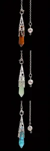 Close-up of three hexagonal crystal stone pendulums with silver hollow-out metal caps.
