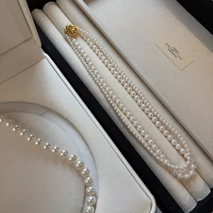 Double-strand elegant white round pearl necklace featuring a gold magnetic clasp closure