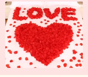 Decorative red artificial rose petals arranged in a heart shape for romantic wedding rooms