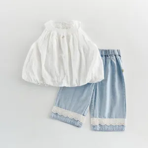 Detailed shot of toddler girl summer clothing set with white blouse and lace denim pants.