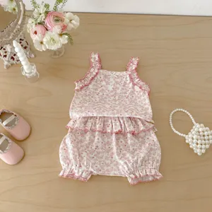Cute baby girl summer floral detail featuring ruffle tank top and bloomers flat lay scene.