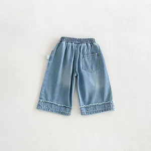 Girls light wash denim wide leg pants with cute heart embroidery and frayed raw hem details.