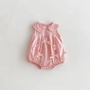 Detalle de mameluco rosa sin mangas para bebé con lazos bonitos y cuello babero clásico.