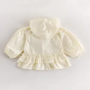 Veste à capuche jaune clair pour tout-petit avec jolis détails de volants et manches longues.