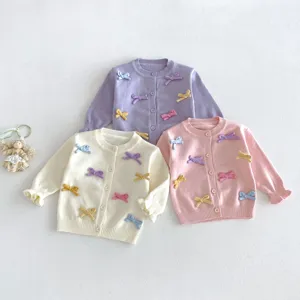 Cute baby girls knit cardigan featuring colorful bow details, soft knitwear for autumn seasons.