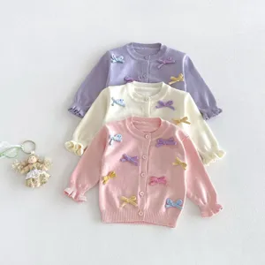 Cute bowknot decorated knit cardigan detail, soft pastel colors and delicate ruffle cuffs.