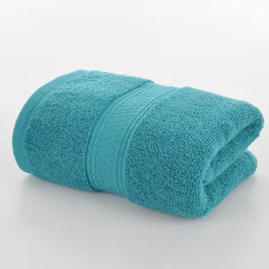 Plain turquoise cotton face towel folded neatly for daily household washing and bathroom use.