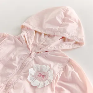 Vue détaillée de la veste rose à capuche pour bébé fille, jolie broderie de fleurs, légère.