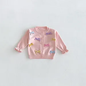 Pink baby girl knitted cardigan sweater detail, cute colorful bow knots and ruffled cuffs.