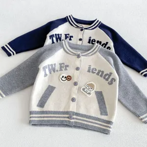 Vue détaillée du gilet en tricot pour enfants avec manches contrastées et broderie.