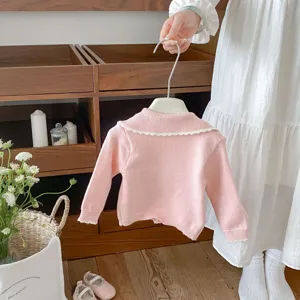 Adorable baby girl pink knit cardigan with cute white lace collar, cozy sweater outerwear.