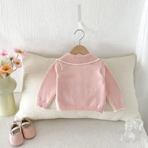 Pink baby girl knitted cardigan detail, cute ruffle collar, soft toddler knitwear close up.
