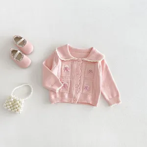 Cute pink baby girl knitted cardigan sweater coat featuring sweet bow details and cute shoes.