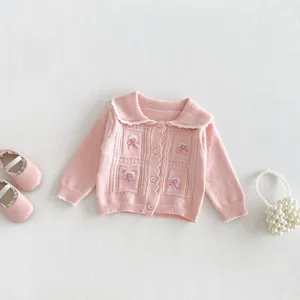 Detailed view of the cute pink baby girl knitted cardigan with lovely bow decor and sweet collar.