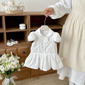 Vue détaillée de la robe d'été blanche pour petite fille avec broderie anglaise et col claudine.