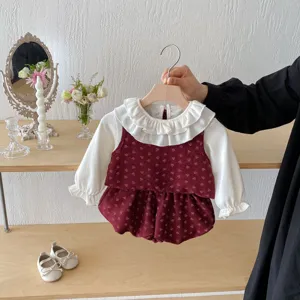Dettaglio set autunnale bambina neonata con camicetta colletto e gilet floreale dolce.