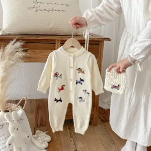 Detailansicht des Baby Strick-Romper Sets in Cremeweiß mit hübschen gestickten Hundemotiven.