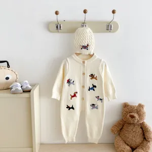 Detailansicht des süßen Baby Strickstramplers mit Mütze, cremefarben mit Hunde-Bestickung.