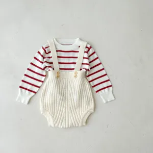 Nahaufnahme des gestrickten Baby-Sets mit Streifenoberteil und gerippter Latzhose mit Knöpfen.