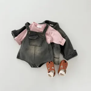 Detailed view of cute infant denim overalls, pink long-sleeve top, and adorable bear shoes.