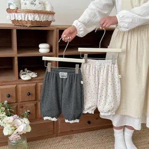 Cute floral toddler trousers detail showing cozy cottagecore style and delicate lace hem.