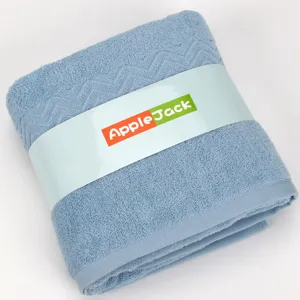Soft cotton bath towel in light blue featuring chevron weave and branded packaging band.