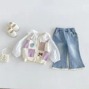 Detailed view of girls spring layering outfit set with knit vest and lace collar blouse.