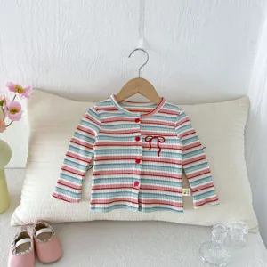 Detailed view of baby girl knitted striped cardigan with cute bow embroidery and buttons.