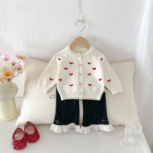 Cardigan in maglia per bambina con ricamo a cuore rosso e pantaloni a zampa a pois.