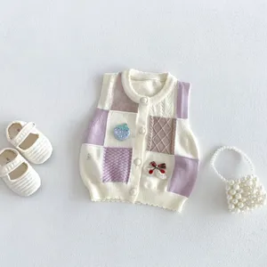 Detailed view of infant knitted cardigan vest featuring sweet strawberry embroidery and patchwork design.