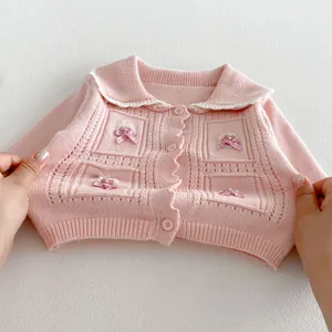 Detailed view of pink toddler knit cardigan collar and cute bow decoration, sweet baby outerwear.