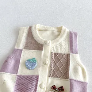 Knit baby vest detail view, featuring cute blue strawberry embroidery, patchwork design, soft texture.