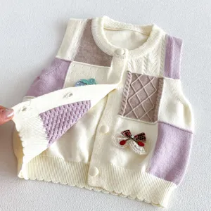 Baby toddler knit cardigan vest detail showing soft fabric, patchwork design, and cute bow accent.