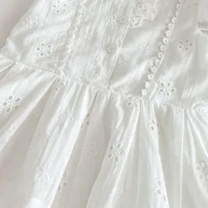 Détail de robe de fille brodée blanche, vêtement léger d'été style princesse jacquard.