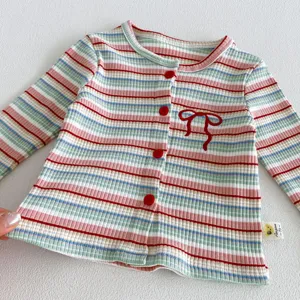 Infant baby striped knitted cardigan detail showing cute red buttons and bow embroidery.