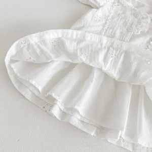 Détail de robe de princesse en coton d'été pour tout-petits filles, broderie anglaise blanche.